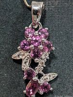 Front view of sterling silver floral pendant with garnet and CZ stones