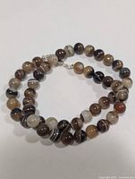 Coiled view of full necklace showing round banded agate beads