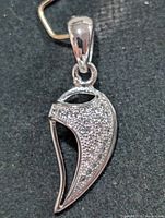 Front view of sterling silver pendant showing pavé stones and openwork shape