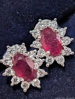 front view of earrings showing ruby centers and CZ halo
