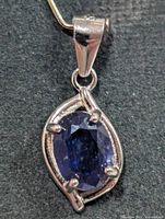 front view of sterling silver pendant with oval blue sapphire
