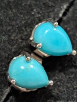 Front view of pear-shaped turquoise earrings in silver setting
