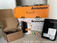 Lenovo IdeaCentre desktop standing beside retail box, white spec label visible