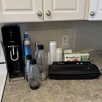 Overall lot showing SodaStream machine, CO2 cylinder, four bottles, FoodSaver vacuum sealer, bag box and rolls