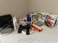 Overall view of Wii console, accessories and game cases on white surface