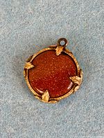front view of round goldstone watch fob
