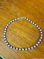 Full view of baroque pearl and crystal necklace on wooden surface