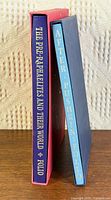 Spines of both Folio Society books in their slipcases showing titles and slipcase colours