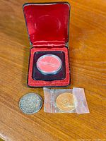 All three coins with Canadian silver dollar in case, Netherlands 25c, and gold-tone Kennedy half
