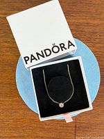 Necklace displayed in open Pandora box