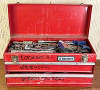 Closed Stanley red toolbox with drawers labeled