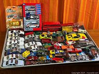 Full tray of assorted diecast vehicles on baking sheet