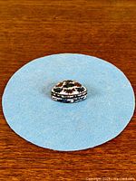 Top view of cloisonné pill box on blue background