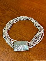 Full view of necklace laid flat showing multi strands and clasp