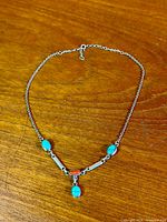 Full view of sterling silver necklace with turquoise and jasper stones laid flat