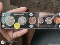 Front view of acrylic holder showing coin reverses and "EARLS PLACE COINS AND STAMPS" text