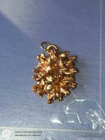 front view of gold-tone floral nugget pendant