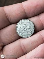 Reverse showing CANADA FIVE CENTS, numeral 5, maple leaves, date 1927