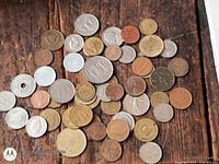 Top view of spread assortment of world coins on wooden surface