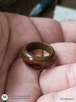 Side view of polished multilayer exotic wood ring held in hand