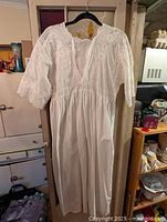 Full view white embroidered day dress on hanger