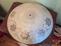 Top view of frosted Art Deco glass ceiling shade showing floral relief and central mounting hole