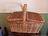 full view of wicker picnic basket showing hinged lids and handle