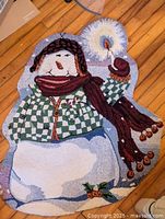 Full view of snowman hooked rug on wood floor