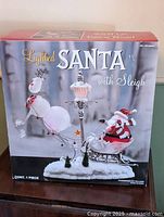 Front of box showing product image and title "Lighted Santa with Sleigh"