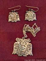 Set showing pendant necklace and matching earrings on fabric background