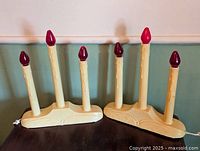 Pair of cream plastic 3-light electric candelabra side by side on table