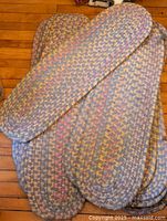 Group of braided stair runners layered on wooden floor