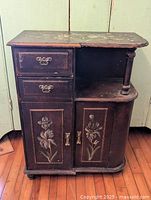 Front view of cabinet showing drawers, doors, floral panels