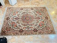 Full view of floral area rug on tiled floor