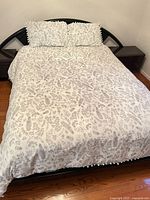 Queen bed with botanical print comforter and shams