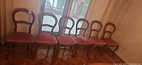 Six matching wood framed chairs in front of window