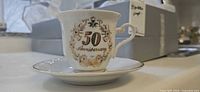 Cup front showing 50 Anniversary motif and saucer