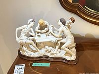 Full view of sculpture showing four card players, wood base, lot sticker visible
