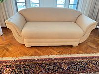 Front view of cream upholstered loveseat