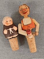 Front view of both carved wooden bottle stoppers