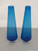 Front view of both blue glass vases standing upright