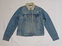 Front view of denim jacket showing overall design, sherpa collar, pockets, button front