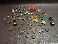 Full layout of assorted costume jewelry pieces on brown surface