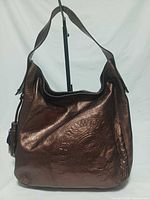 Front view showing bronze metallic leather, embossed crest, tassel charm