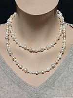 Necklace doubled around mannequin neck showing pearl colours and luster