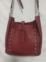 Front view of burgundy Rebecca Minkoff leather hobo bag with stud accents