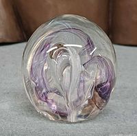 Front view of spherical paperweight showing internal purple and white swirls