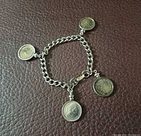 Bracelet laid flat showing four coin charms