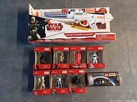 Group shot of boxed Clone Trooper Blaster, eight Hallmark ornament boxes, lightsaber kit tube