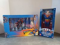 Front view of boxed Superman motion lamp and boxed 12-inch Superman figure